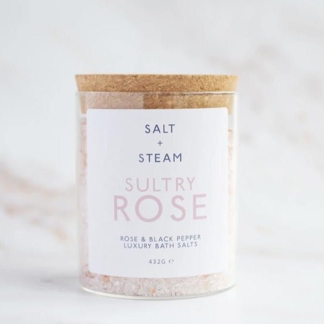 Glass jar with cork lid, holding pink and white salt crystals