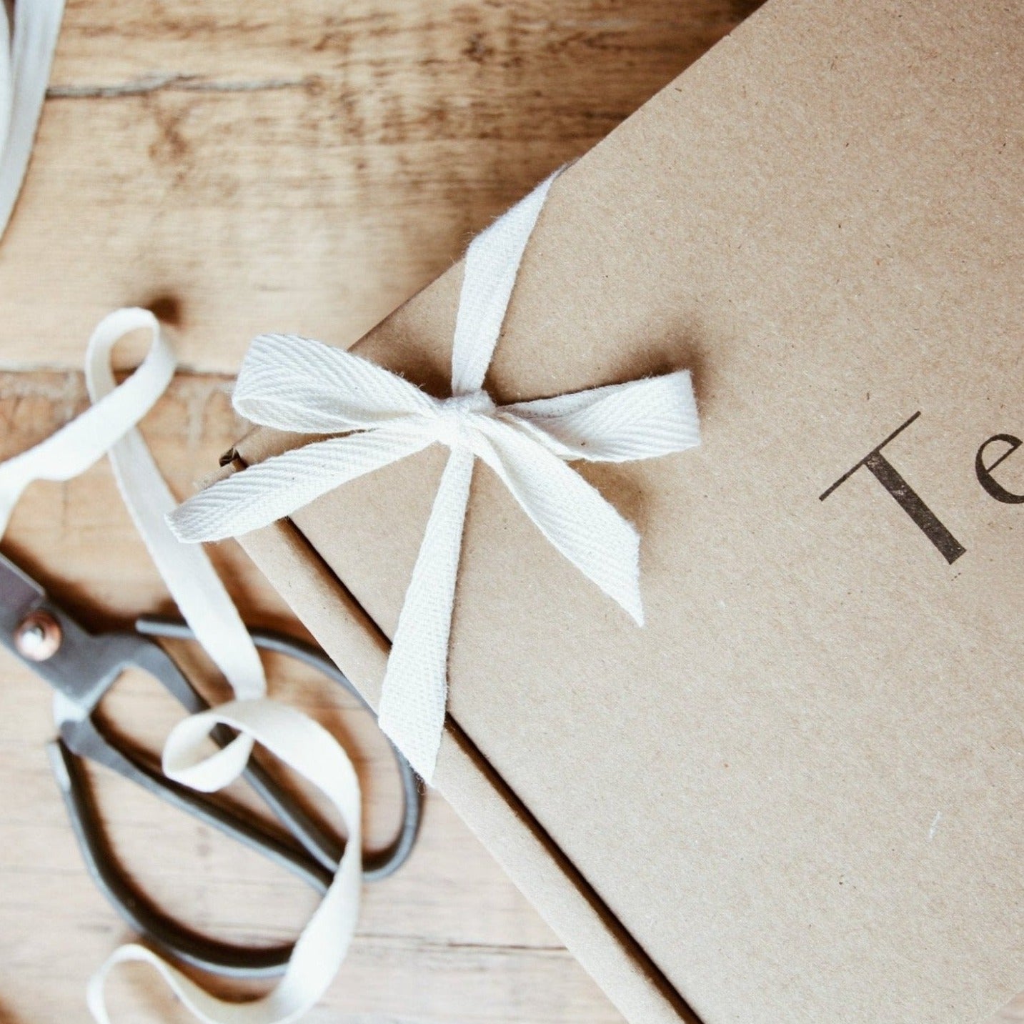 brown box tied with cream ribbon and stamped with logo