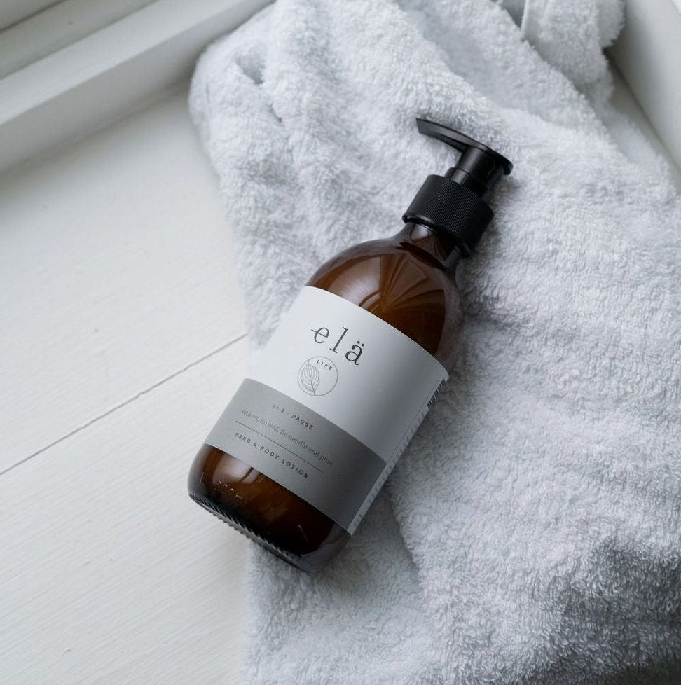 amber glass bottle with pump dispenser laid on a fluffy grey towel