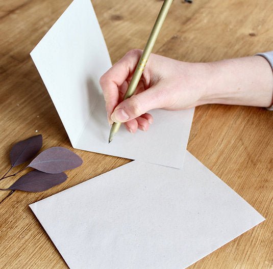 hand writing a message in an open card