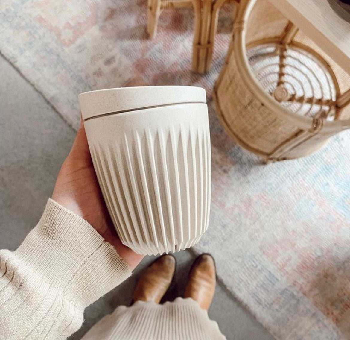 hand holding cream coffee cup