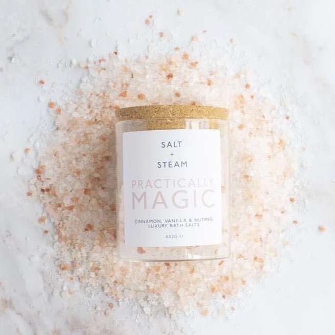 a corked glass jar laid on a pile of white and pink salt crystals