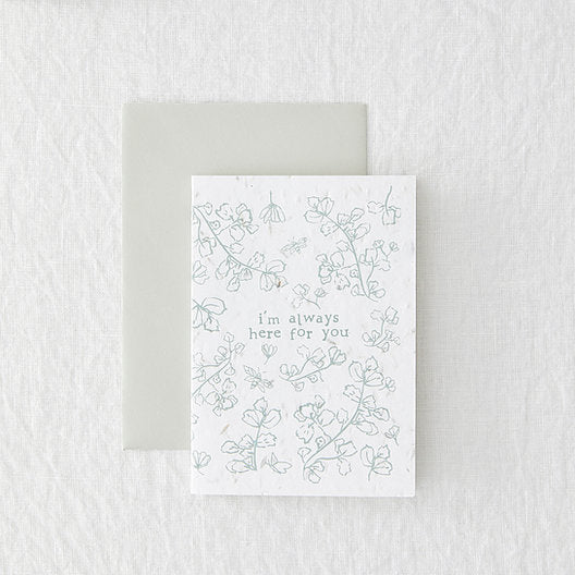 white card with grey floral design, laid on a grey envelope