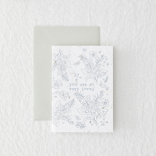 white portrait card with grey floral design, laid on a grey envelope