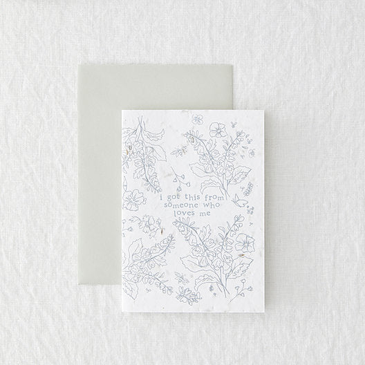 white portrait card with grey floral design, laid on a grey envelope