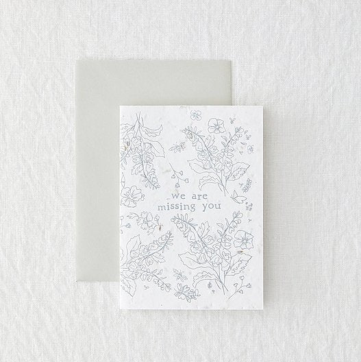 white greetings card with grey floral design, laid on a grey envelope